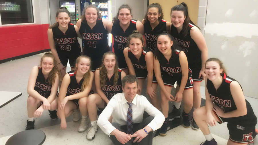 Girls basketball varsity team players posing with Coach Chris Carrico after achieving a states berth. (Photo Courtesy of Becki Creed)