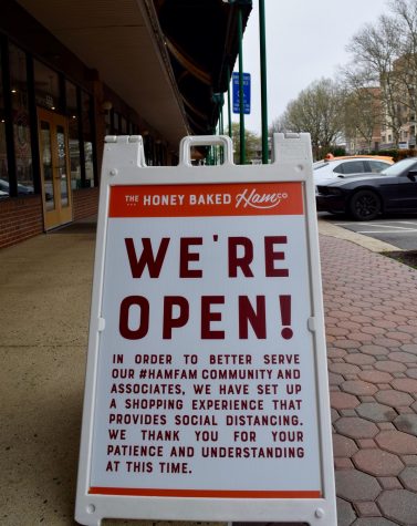 A sign in front of Honey Baked Ham reads "We are open!"