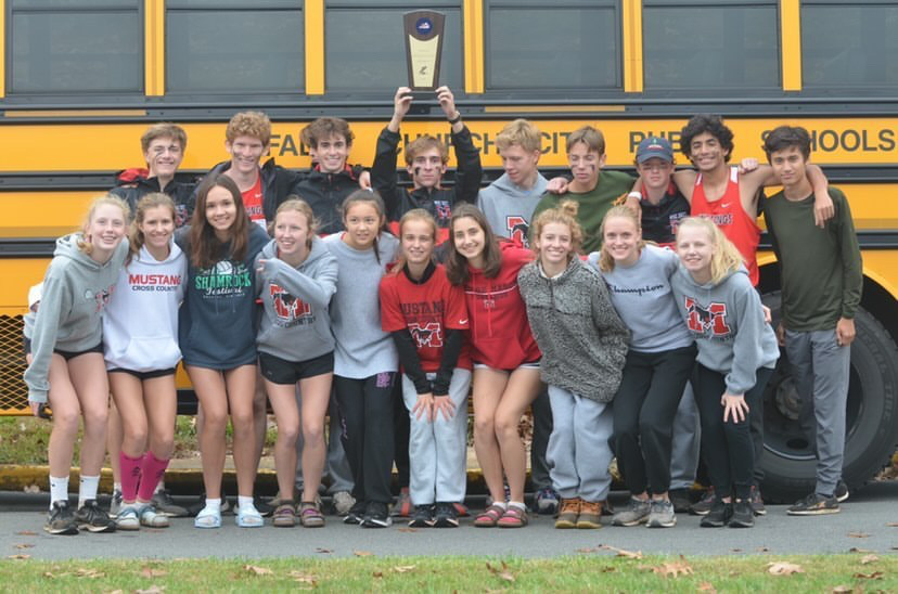 Cross country team poses after a successful regional meet where they qualified for the state meet.