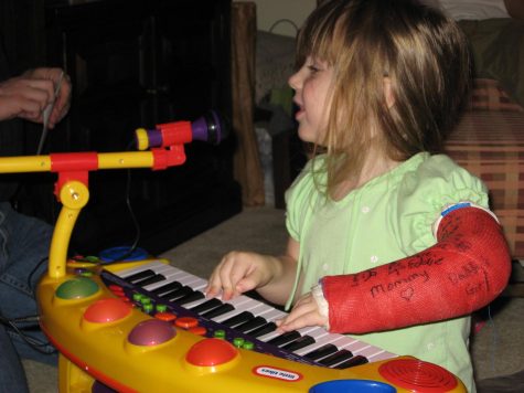 Theisz on her third birthday, with a broken arm playing and singing her heart out with her beloved toy piano.