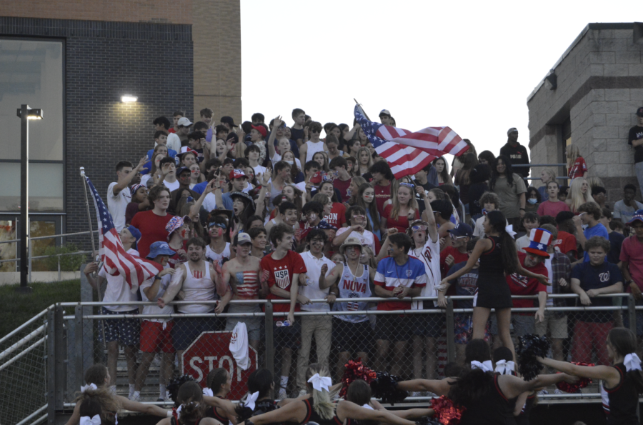 The USA-themed student section gets pumped for the start of the football game by doing the Mustang Rumble.
