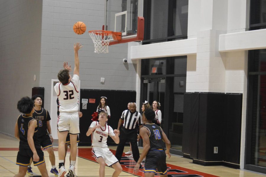 Junior Grant Griener (32) floats the ball over his opponents and into the basket. (Photo by Sasha Kasher)