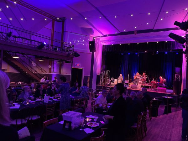 The theater was decorated with colorful lighting and dining tables so attendees could enjoy their dinner with live music. (Photo by Tessa Kassoff)