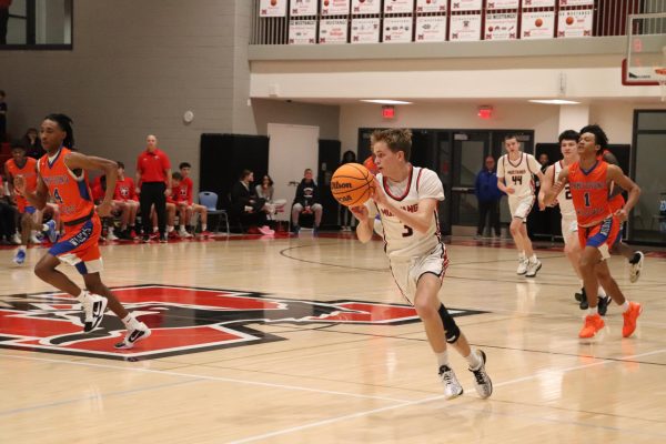 Junior Isaac Rosenberger dribbles the ball down the court. (Photo by Rachel Grooms)