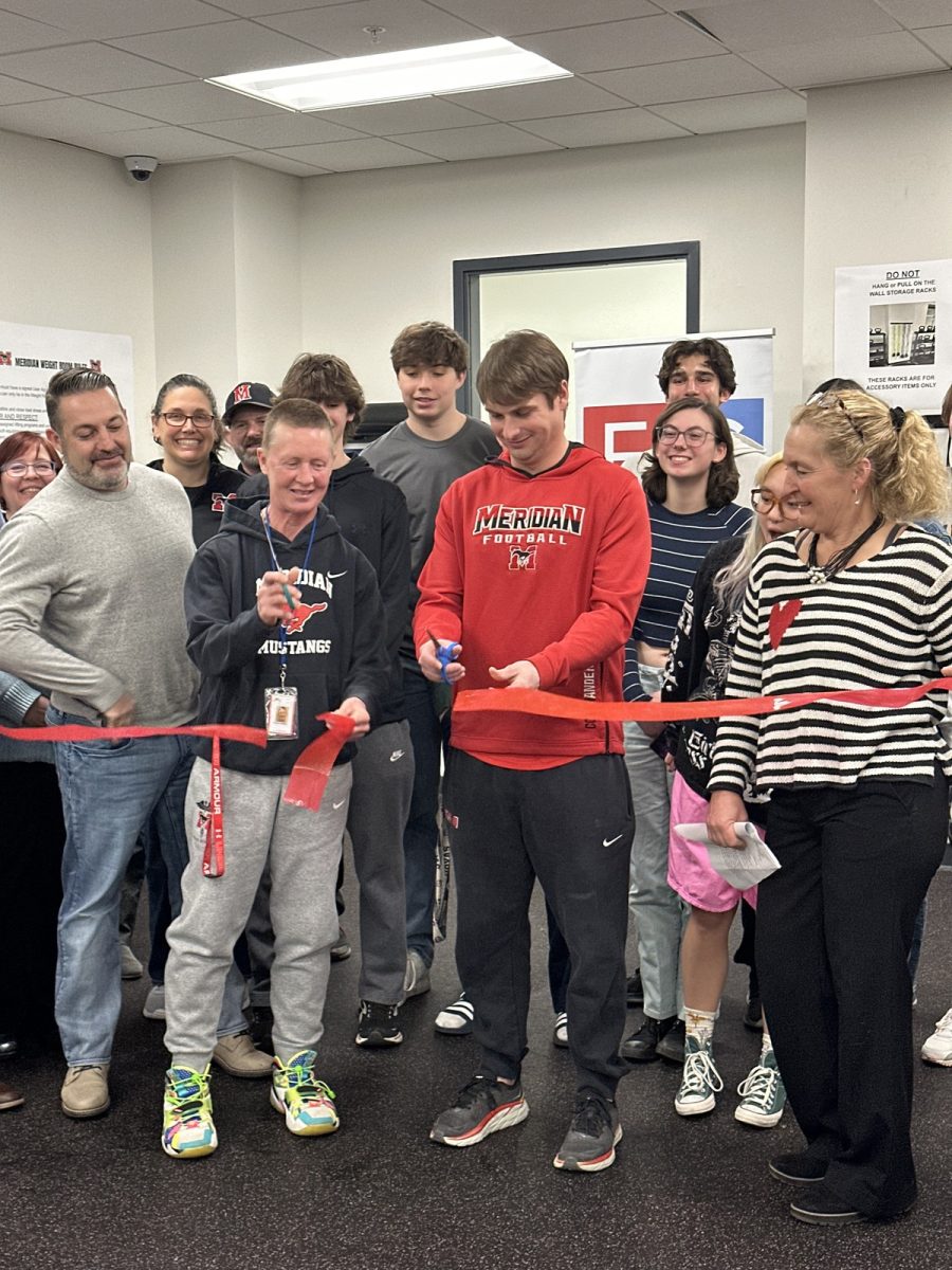 Coach PJ Anderson and Coach Vicki Galliher lead the ribbon cutting to officially open the renovated weight room. (Photo by Ryan Degnan)