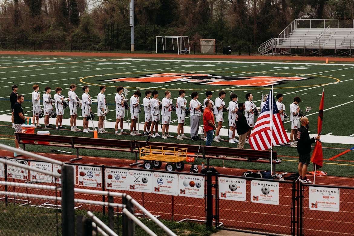The team lines up for the anthem before a rainy home game. (Photo from Connor Fleming via fitzperfect_photography on Instagram.)