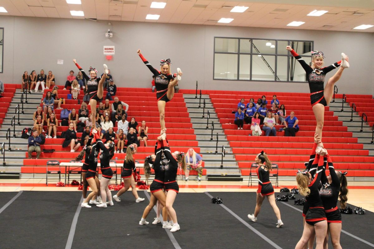 Juniors Brooke Birdwell and Ela Rees, and freshman Cora Brock do the low to high heel stretch stunt. (Photo by Liliane Bonnenfant)