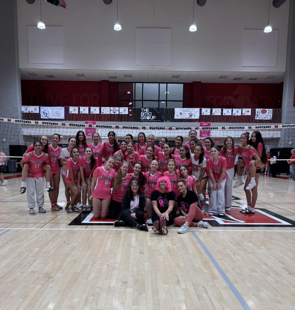 JV, Varsity, and the coaches pose for a photo to celebrate their double win for Dig Pink. (Photo courtesy of Addie Ziegler)