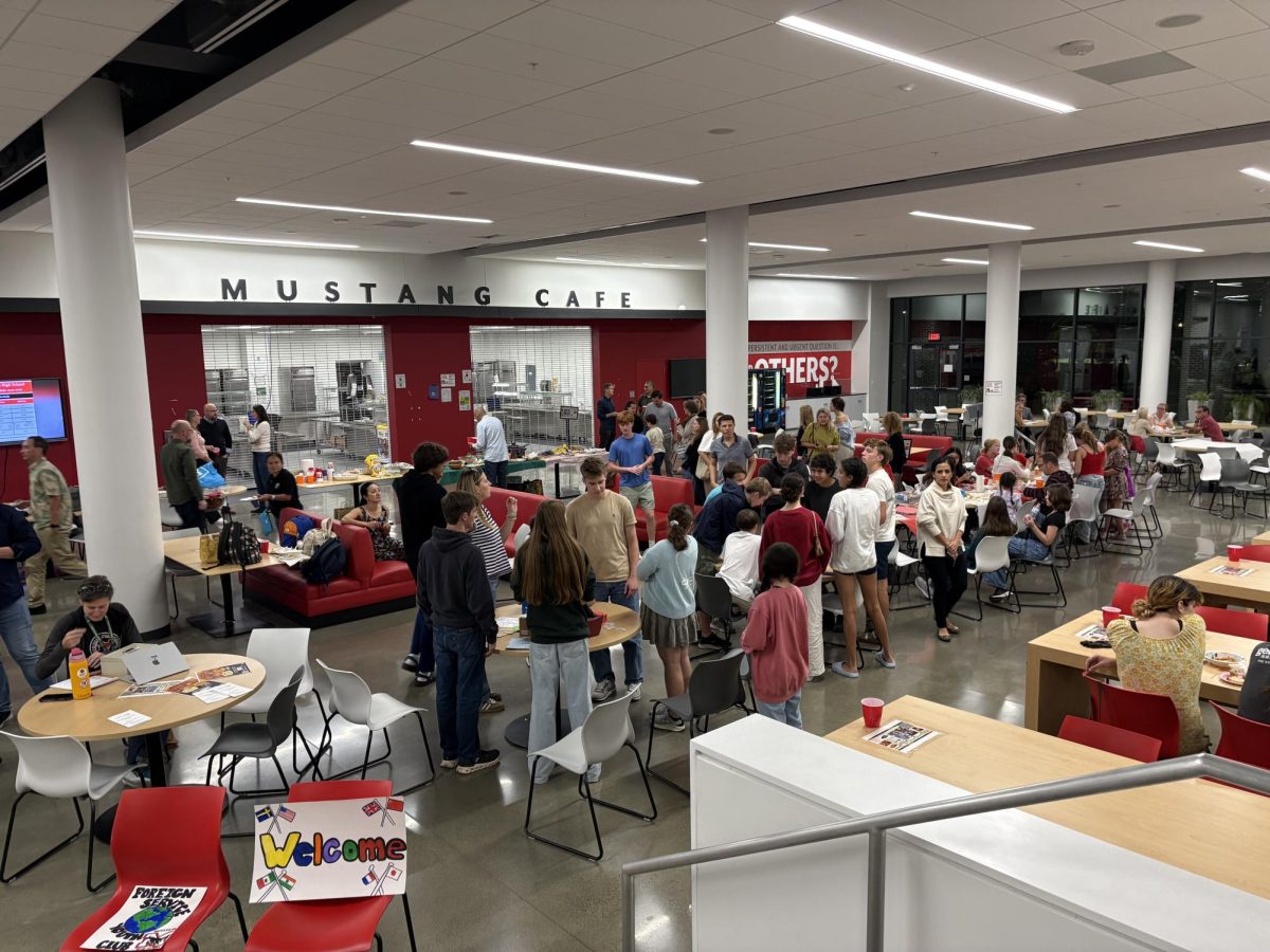 Students and parents of Foreign Service families mill about the event, eating at the potluck or doing arts and crafts. (Photo by Binyamin Hassan)