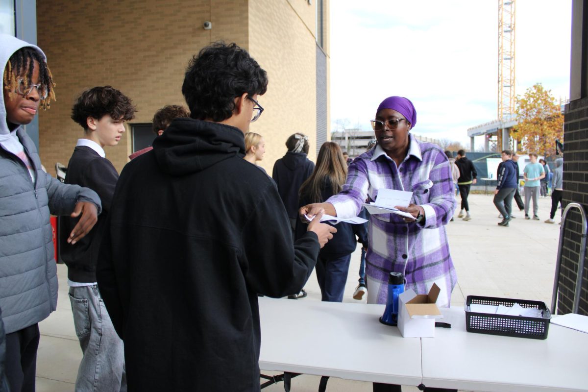  Ms. Adetoro hands out flyers to students. (Photo by Tessa Dunn)