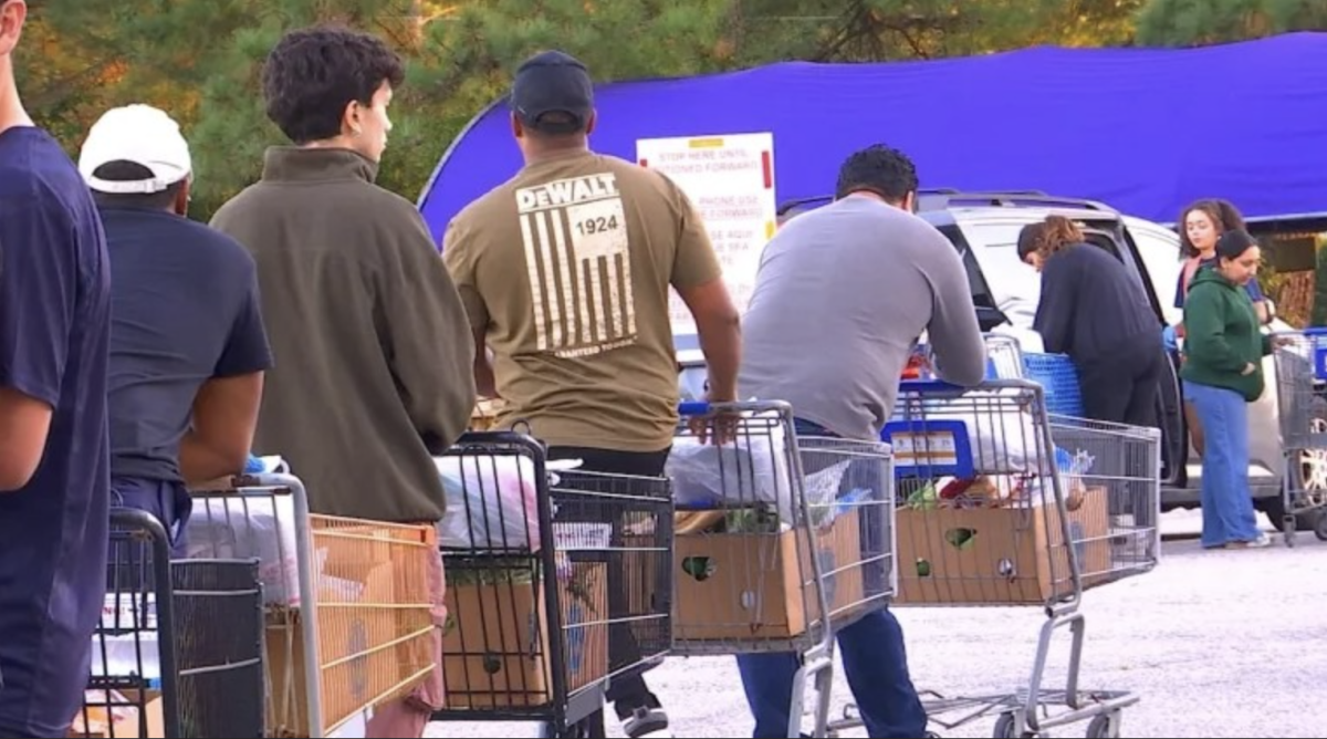 Volunteers line up with grocery carts full of food donations to deliver to cars at the Chesterfield Food Bank Outreach Center. (Photo via Federation of VA Food Banks)