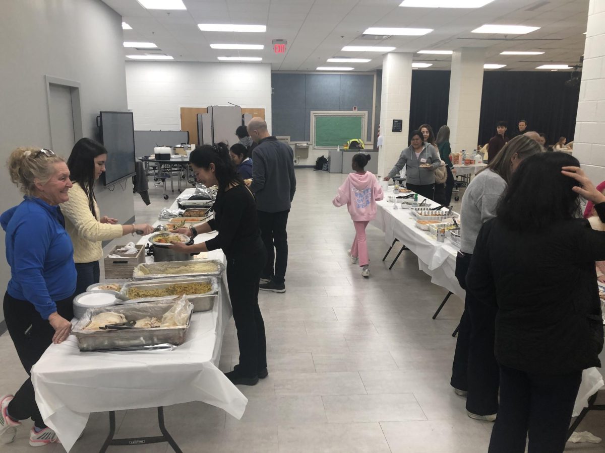 Falls Church families help themselves to a Thanksgiving feast after school in the MEH cafeteria. (Photo by Binyamin Hassan)