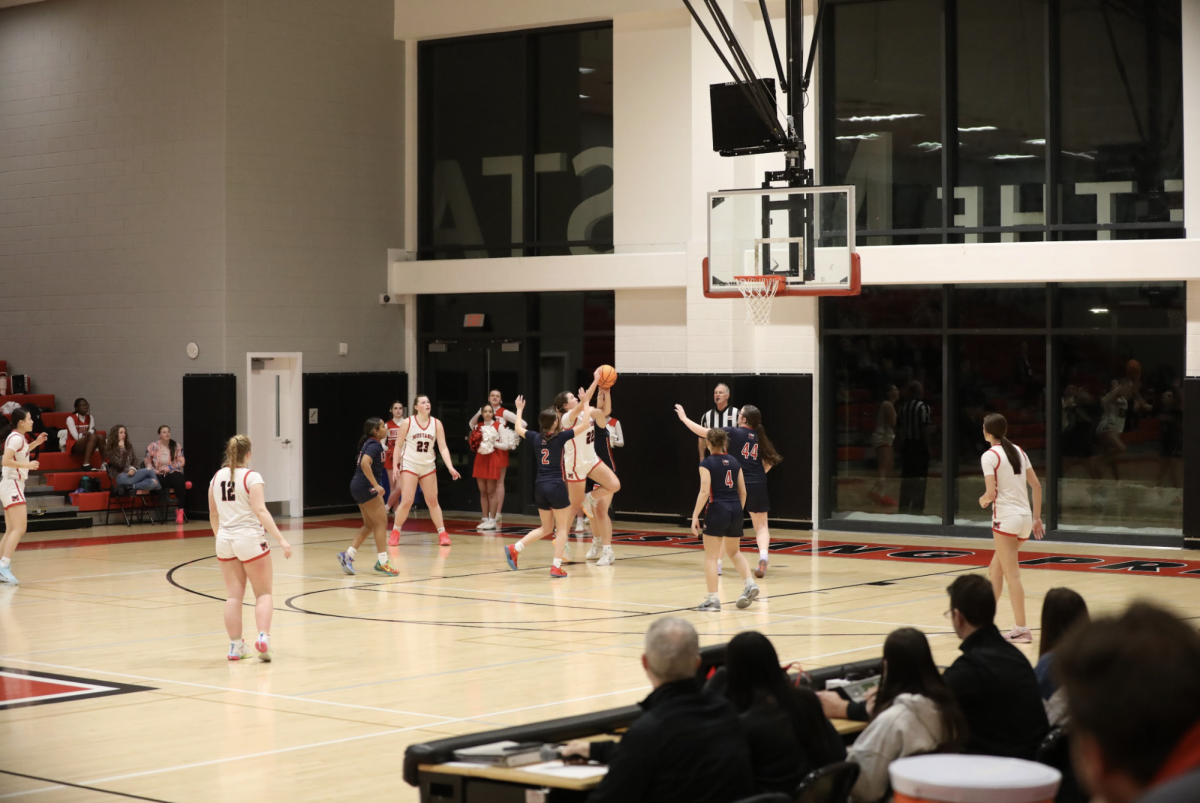 Mustangs surround the offensive end while senior Anisa Frey drives the basket. (Photo by Ryan Degnan)