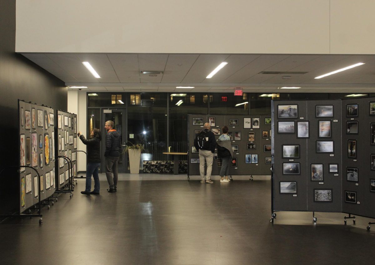 Parents peruse displays of photography and art on the third floor. (Photo by Gianna Hunter)