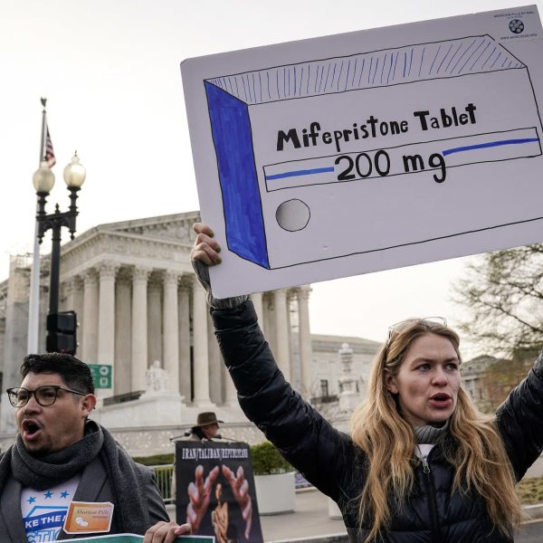 Protestors holding up signs of the 200mg abortion pill mifepristone 